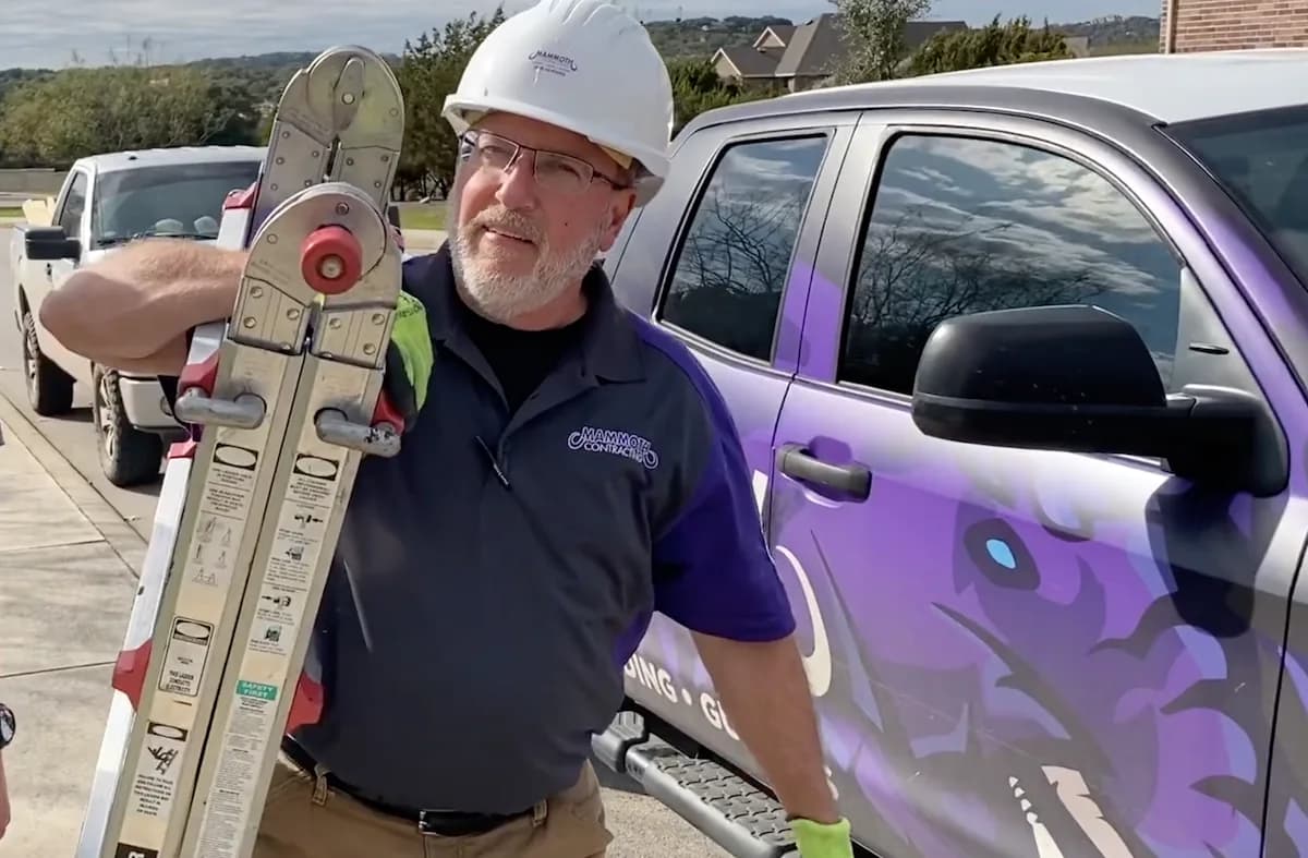 A Mammoth team member with a ladder beside the company truck