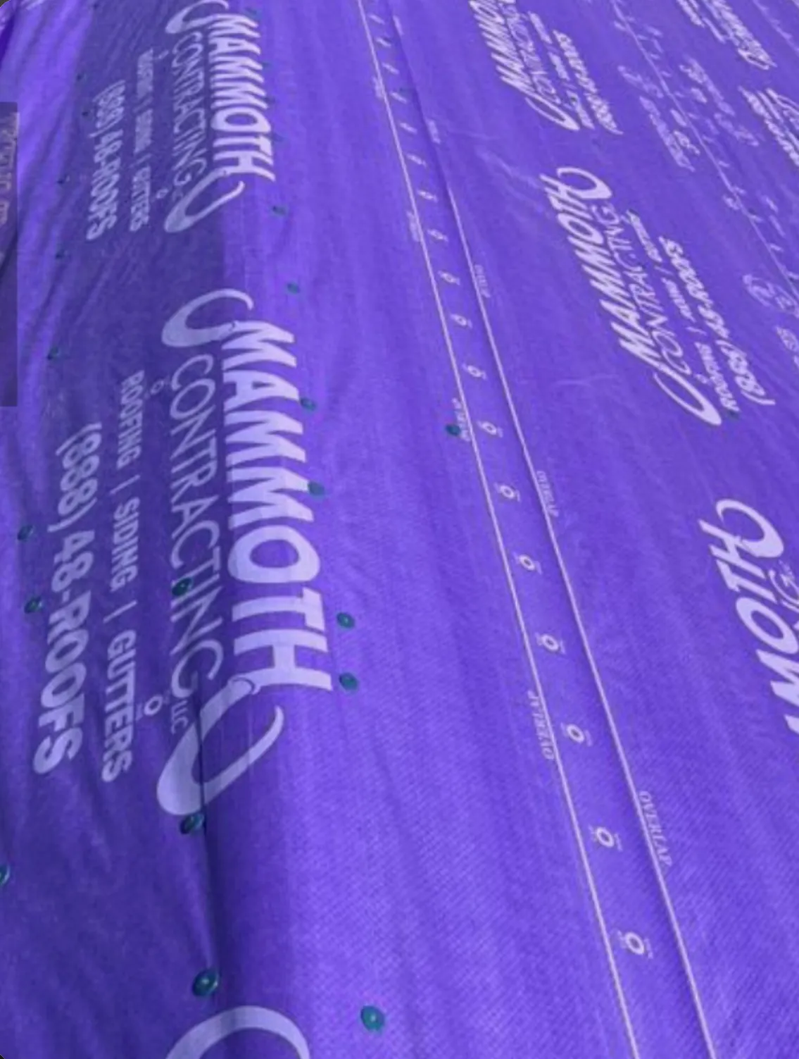 Purple Mammoth-branded synthetic underlayment fastened across a roof deck