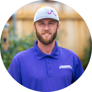 Aaron Massey - Roofing Specialist at Mammoth Roofing & Solar, wearing a purple polo and gray company cap, smiling in an outdoor setting.