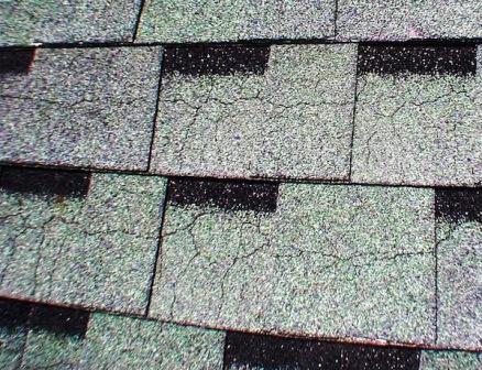 Freezing Temps Can Damage Your Roof. Asphalt shingles with visible craze cracking caused by freezing temperatures and roof aging.