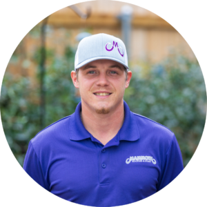 Landon Sinclair, a roofing specialist at Mammoth Roofing & Solar, wearing a branded company polo and cap in an outdoor setting.
