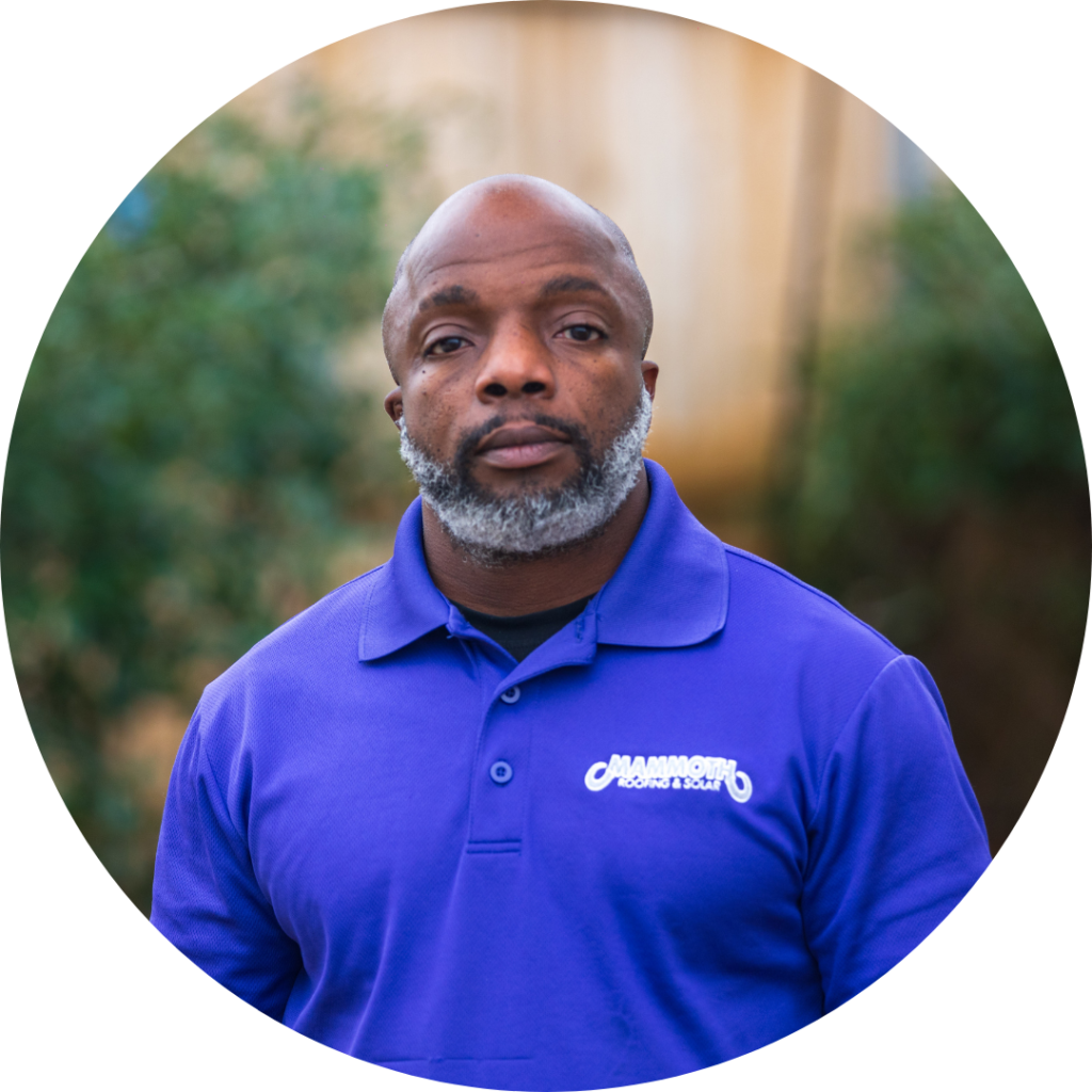 Raymond Livingston, a roofing specialist at Mammoth Roofing & Solar, wearing a branded company polo in an outdoor setting.