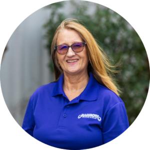 Alison Landvik, team member at Mammoth Roofing & Solar, smiling in a company polo with a natural background.