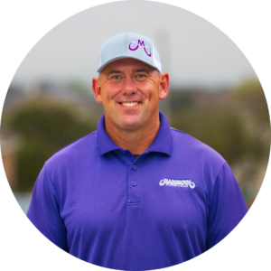 Keith Orie, Mammoth Roofing & Solar team member wearing branded uniform and hat, smiling on a residential street.